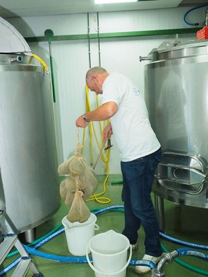 Sytze Hoogstins haalt de kruidenbuiltjes met gagel uit de kokend hete worttank. Loonbrouwer Gerrit Admiraal helpt hem daarbij, want de zakjess zijn na enkele minuten trekken loodzwaar geworden.