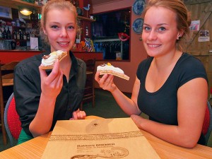 Sanne Ronner uit Ferwert (links, 18 jaar, studente design) en Marlies Douwes (17 jaar, HAVO 5-leerling uit Blija) weten het: de oranjekoek van bakker Bremer is altijd goed voor complimenten. De dames hebben een bijbaantje in het restaurant van Seedykstertoer in Marrum.